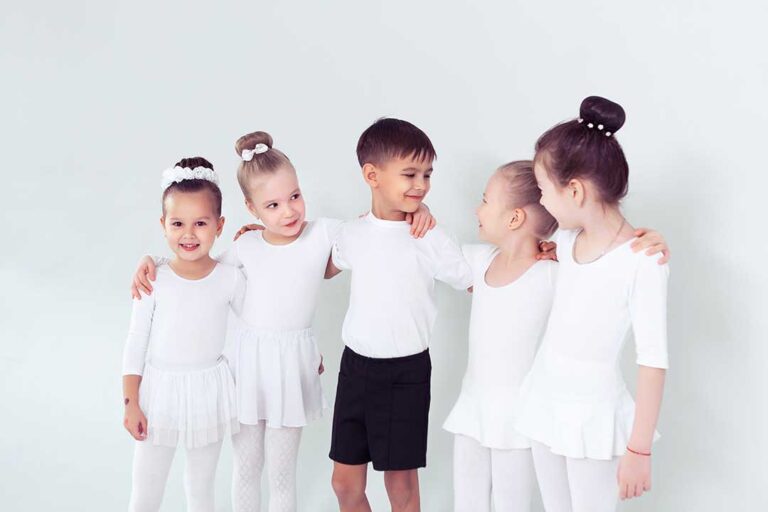 Parent watching a young dancer practice footwork in a bright studio with dance shoes nearby